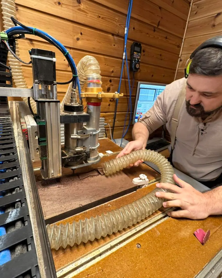 Cutting the desk's walnut bow-tie inlays on the CNC machine.