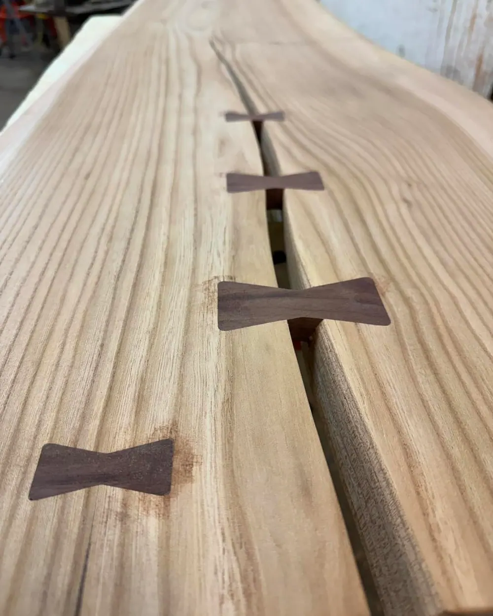 The elm desk with dark walnut bow-tie inlays, made by Dino in the Craftasaurus workshop.